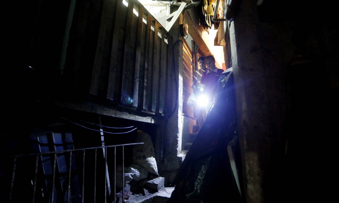 
Moradores do Dona Marta usam lanterna em viela da favela
Foto: Guito Moreto / O Globo