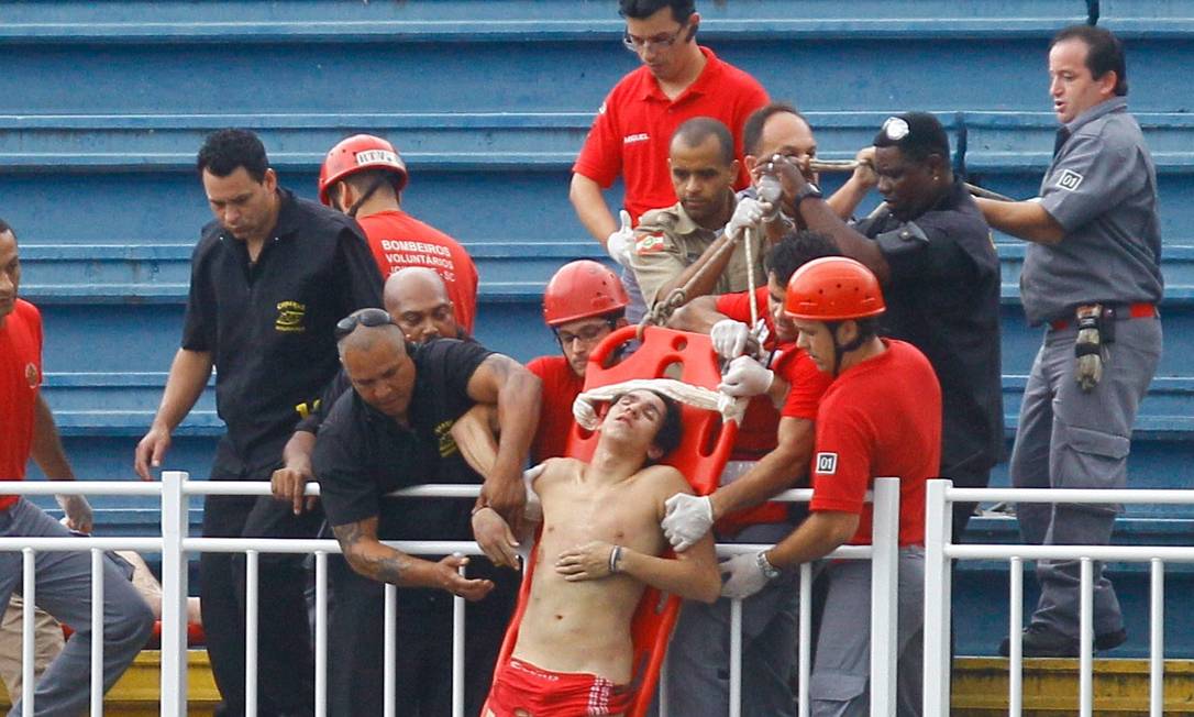 Rapaz é retirado de maca da arquibancada do estádio em Joinville após violência entre torcidas de Atlético PR e Vasco, na última rodada do Campeonato Brasileiro de 2014 Foto: Pedro Kirilos / Agência O Globo