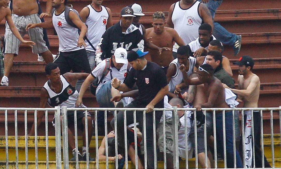 Torcedores do Vasco espancam um torcedor do Atlético-PR na Arena Joinville: cena se repetiu dos dois lados Foto: Pedro_Kirilos / Agência O Globo