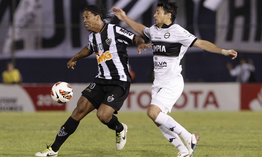 
Aranda tenta marcar Ronaldinho no jogo em que o Olimpia enfrentou o Atlético-MG na última Libertadores. Volante vai assinar por três anos com o Vasco
Foto: Cesar Olmedo / AP