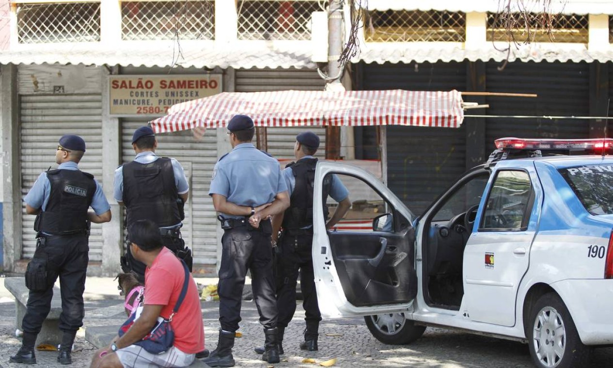 Policiais fazem segurança no Largo do Pedegulho, onde o comércio está fechado nesta segunda-feira Foto: Pablo Jacob / O Globo