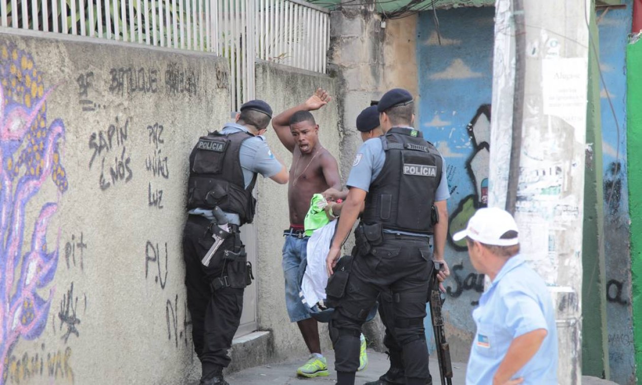 Princípio de confusão entre um morador e PMs durante revista na Mangueira Foto: Bruno Gonzalez / Agência O Globo