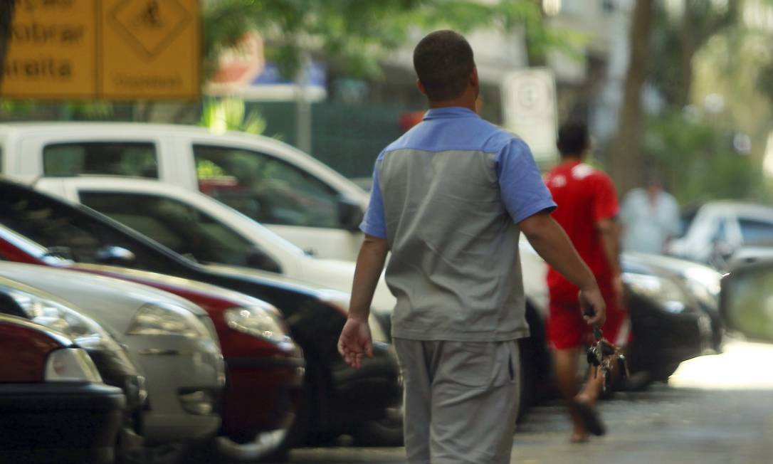 
Vendedor de talões desfila com um molho de chaves dos carros estacionados; ao fundo, um flanelinha que divide a rua com ele
Foto: Gabriel de Paiva / O Globo
