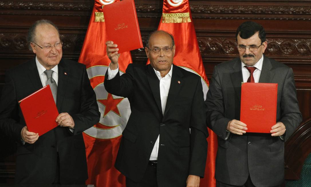 
À esquerda, o presidente da Assembleia Nacional da Tunísia, Mustapha Ben Jaafar, o presidente Moncef Marzouki, e o primeiro-ministro Ali Larayedh, à direita, após a assinatura da nova Constituição
Foto: ANIS MILI/Reuters