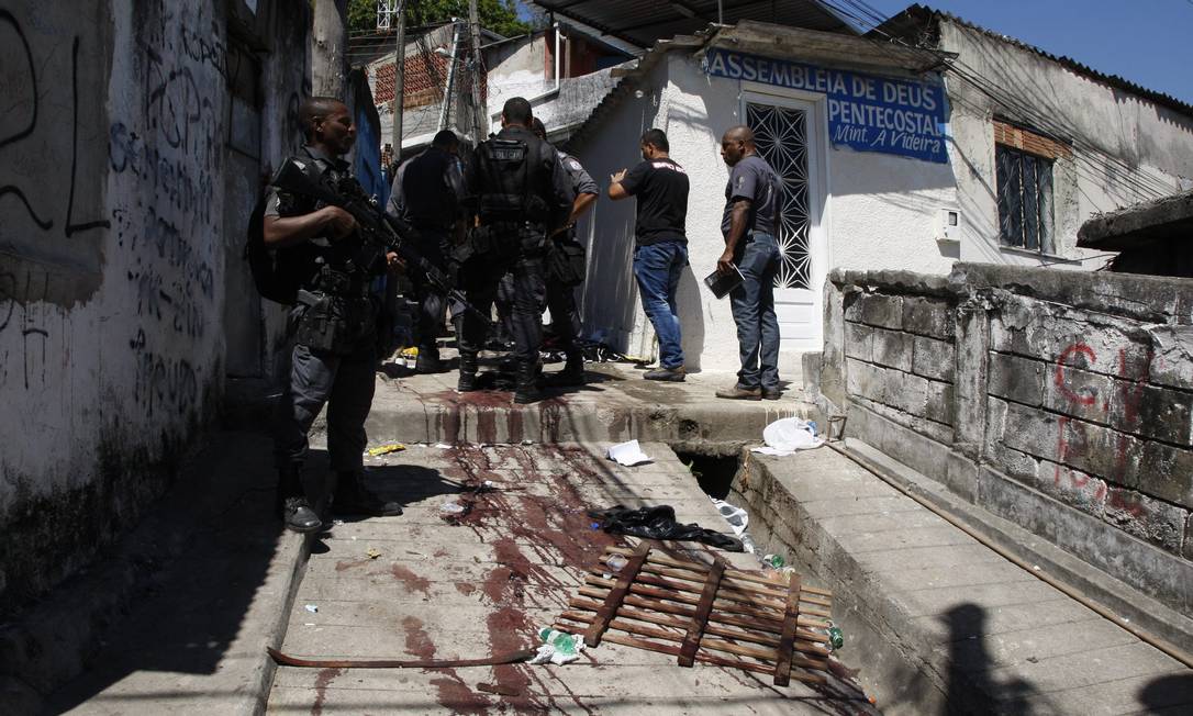 Policiais militares durante operação no Morro do Juramento. No chão, marcas de sangue Foto: Marcos Tristão / O Globo