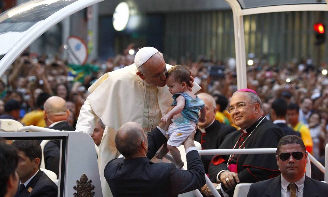Papa beija uma criança durante o passeio em carro aberto na Rio Branco, durante Jornada Mundial da Juventude. Multidão foi receber Francisco Foto: Agência O Globo