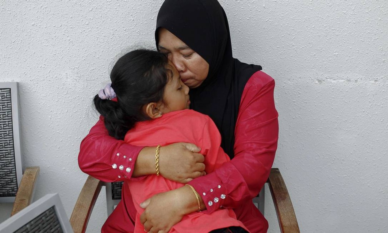 Rosila Abu Samah, 50, and her daughter Kaiyisah Selamat, 8, the mother and sister of flight engineer Mohd Khairul Amri Selamat who was on board missing Malaysia Airlines flight MH370, hug each other during an interview inside the hotel where they and other relatives of the passengers of the missing Boeing 777-200ER are staying in Putrajaya March 20, 2014. REUTERS/Samsul Said (MALAYSIA - Tags: DISASTER TRANSPORT) Foto: SAMSUL SAID / REUTERS