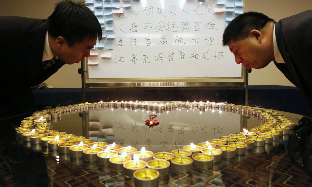 Hotel workers put out candle lights dedicated to passengers onboard the missing Malaysian Airlines flight MH370 after the prayer for the passengers was finished at a hotel in Beijing March 20, 2014. The FBI is helping Malaysian authorities to analyse data from a flight simulator belonging to the captain of a missing Malaysian airliner, a U.S. official said on Wednesday as investigators grasped for clues 12 days after the plane vanished. The words on the board read "praying for the safe return of family members". REUTERS/Kim Kyung-Hoon (CHINA - Tags: DISASTER TRANSPORT SOCIETY) Foto: KIM KYUNG-HOON / REUTERS