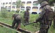 Soldados do Exército procuram armas na horta num Ciep, no Complexo da Maré