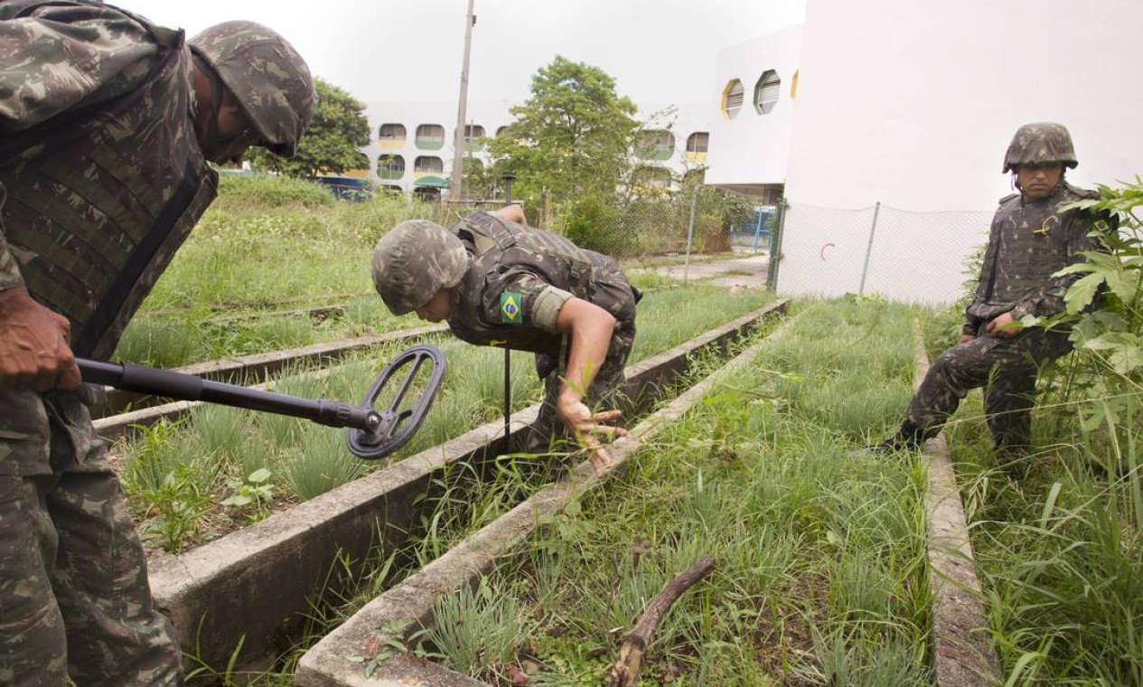 Homens do exército procuram armas na horta do Ciep Samora Machel Foto: Márcia Foletto / Agência O Globo