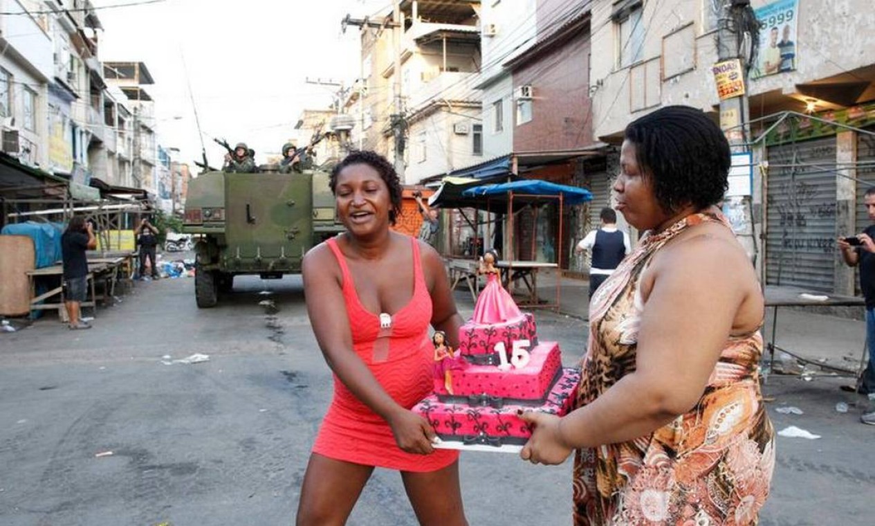 Moradoras da Maré carregam bolo de aniversário: festa no dia da ocupação do complexo Foto: Pablo Jacob