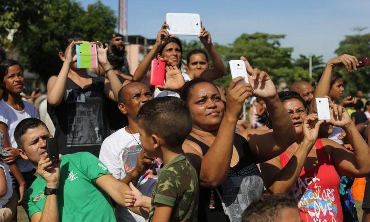 Moradores da Maré registram a ocupação com seus celulares e tablets Foto: Leo Correa / AP