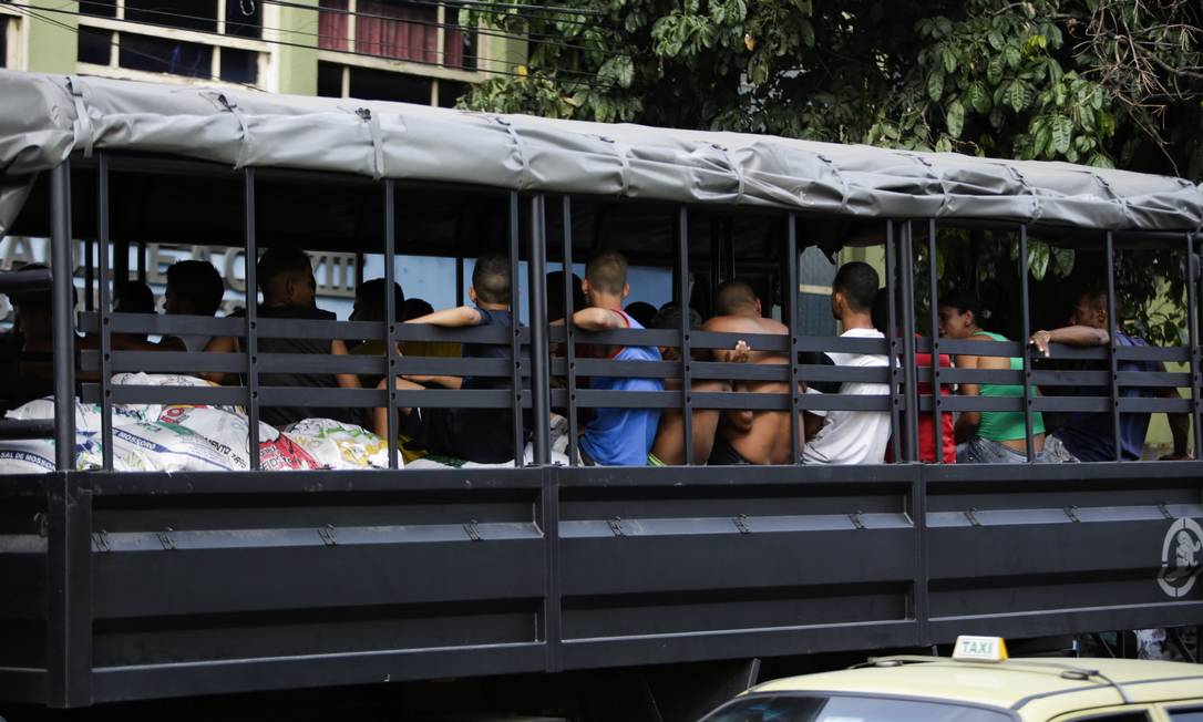 Jovens detidos são levados para a delegacia: acusados de jogar pedras na Linha Vermelha Foto: Fabio Seixo / Agência O Globo