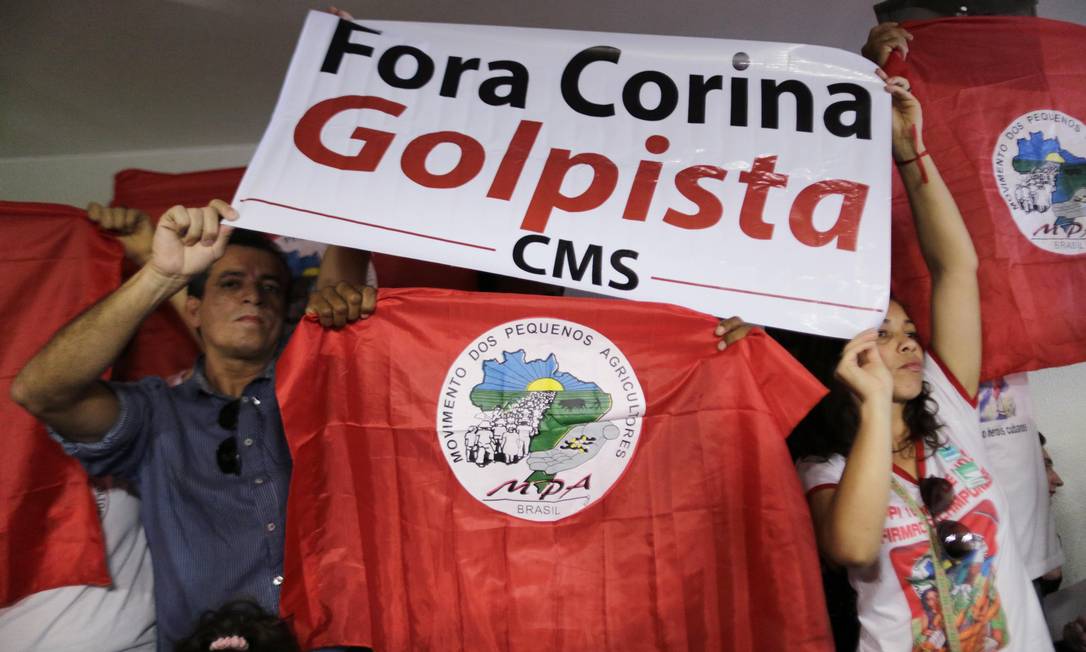
Manifestantes seguram bandeira que diz “Fora Corina, golpista” durante o discurso do líder da oposição venezuelana
Foto: UESLEI MARCELINO / REUTERS
