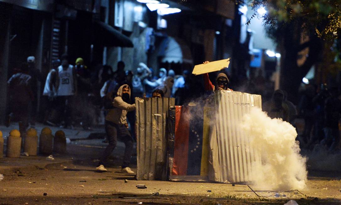 
Manifestantes e membros da Polícia Nacional se enfrentam em Caracas
Foto:
JUAN BARRETO
/
AFP
