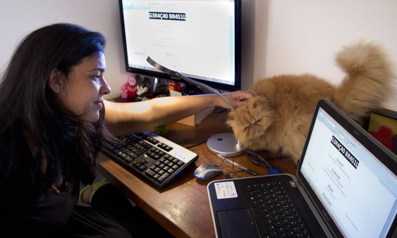 Izabel costuma escrever acompanhada de seu gato: 'De vez em quando ele sobre no teclado', conta Foto: Simone Marinho / Agência O Globo