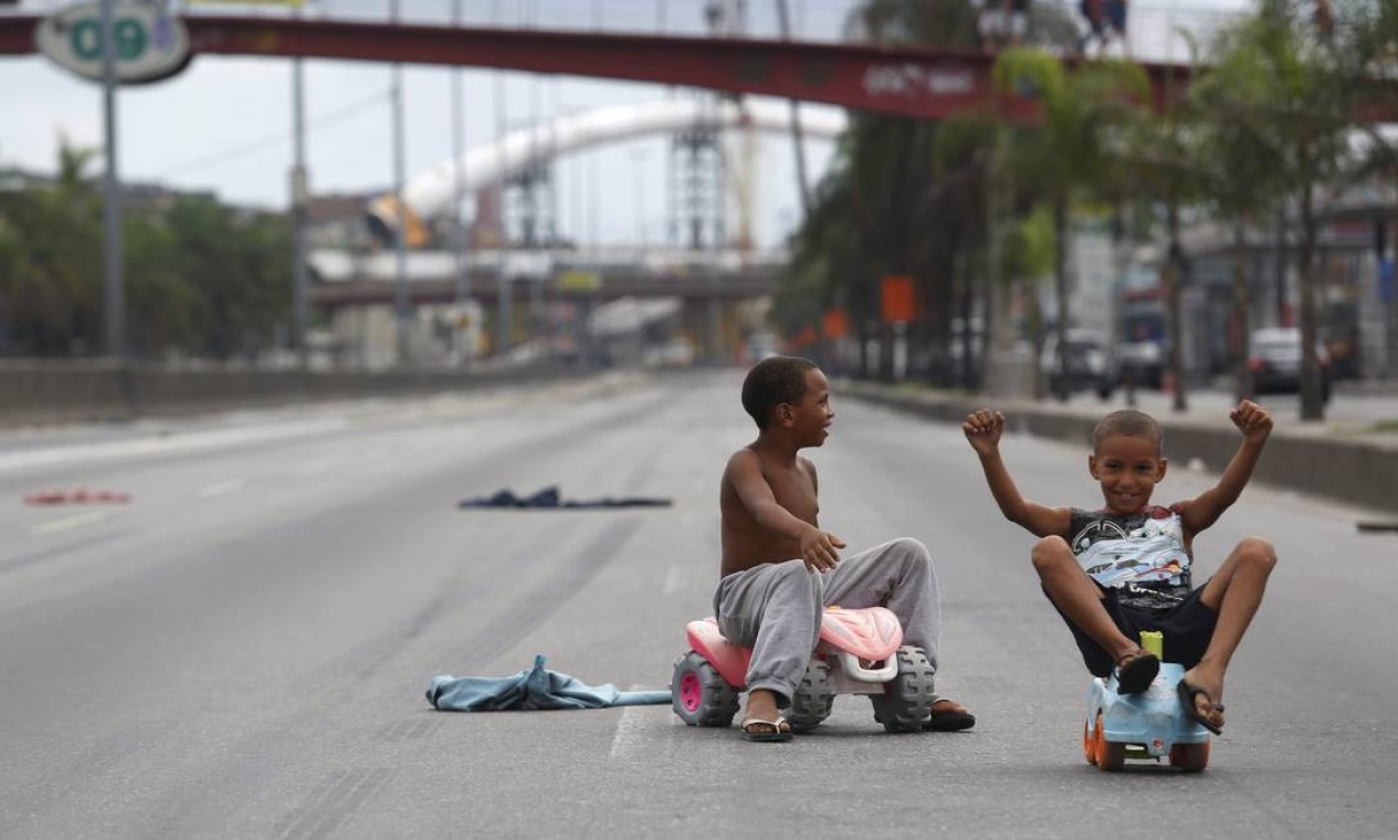 Meninos brincam na Avenida Brasil, interditada para obras Foto: Custódio Coimbra / O Globo
