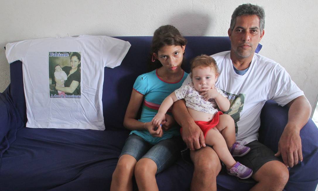 
Jaílton com as filhas Yasmin e Ester, ao lado da camisa com a foto de Fabiane
Foto:
/
Marcos Alves/ O Globo
