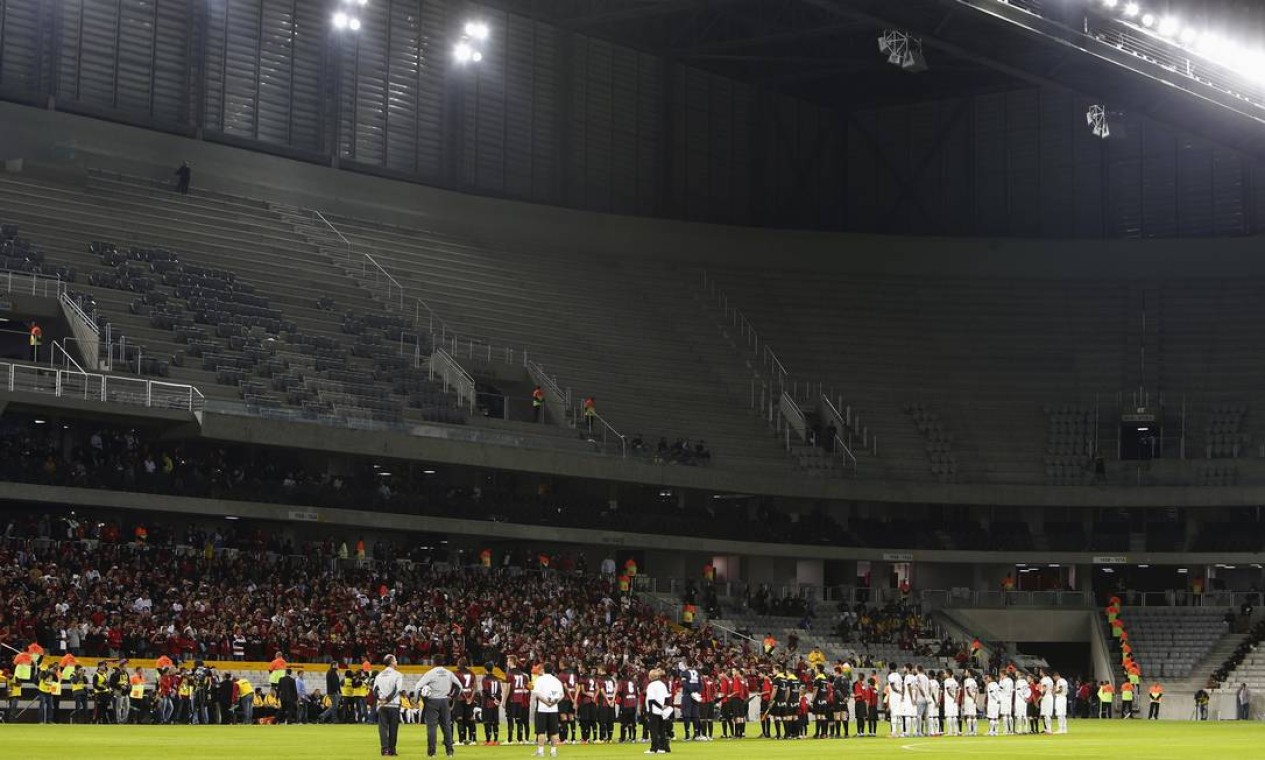 Players from Atletico Paranaense (red) and Corinthians line up before playing a friendly match to test the Arena da Baixada stadium under construction for the World Cup in Curitiba, May 14, 2014. The Arena da Baixada is considered by FIFA as the stadium with the greatest delays with less than a month to go for the tournament to begin. REUTERS/Rodolfo Buhrer (BRAZIL - Tags: SPORT SOCCER WORLD CUP) Foto: RODOLFO BUHRER / REUTERS