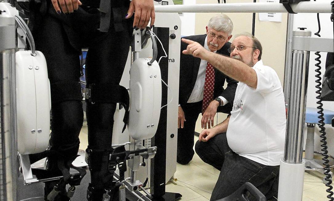 
Nicolelis (de branco) mostra para Collins o exoesqueleto que fará com que um jovem paraplégico dê primeiro chute da Copa do Mundo
Foto:
/ Fernando Donasci
