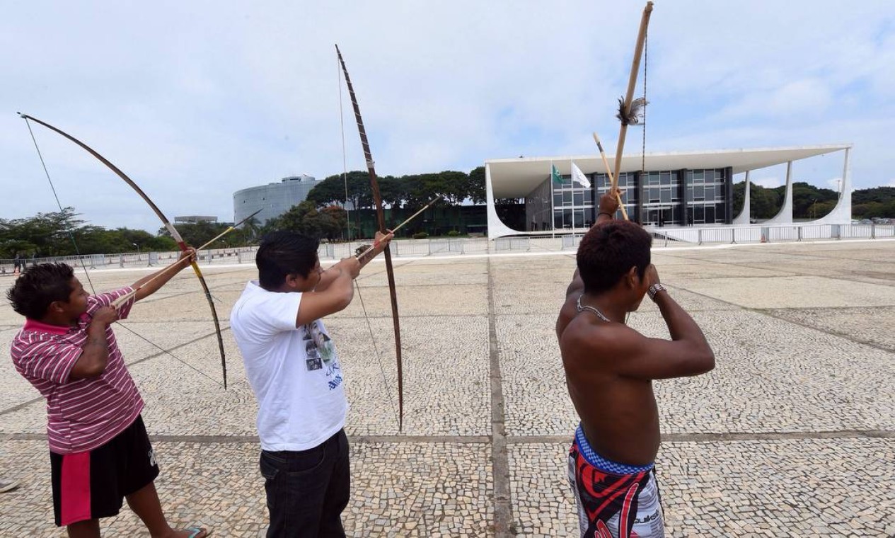 Brazilian natives from different ethnic groups aim their bows to the Planalto palace, the official workplace of Brazil's Presidency during a protest in Brasilia on May 27, 2014. The demonstration is aimed to attract the attention on the Amazonia situation in the framework of next FIFA World Cup. AFP PHOTO/Evaristo SA Foto: EVARISTO SA / AFP