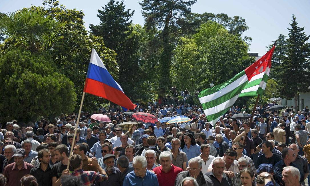 
Com bandeiras da Rússia e da Abcázia, manifestantes protestam do lado de fora da sede do governo da província georgiana, palco do conflito entre a Rússia e a Geórgia, em 2008
Foto:
/
REUTERS
