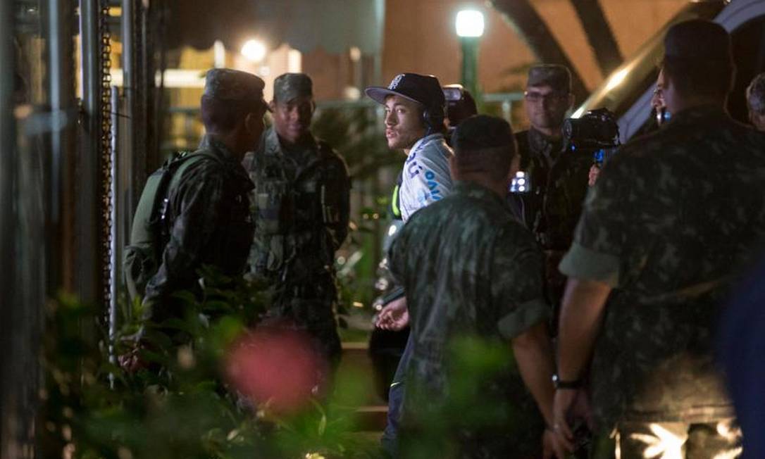 Cercado por soldados, Neymar entra no hotel da concentração da seleção brasileira em Goiânia Foto: Alexandre Cassiano