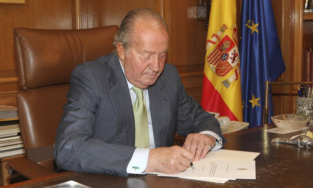 Em foto divulgada pelo governo espanhol, o rei Juan Carlos I assina sua abdicação ao trono Foto: AP