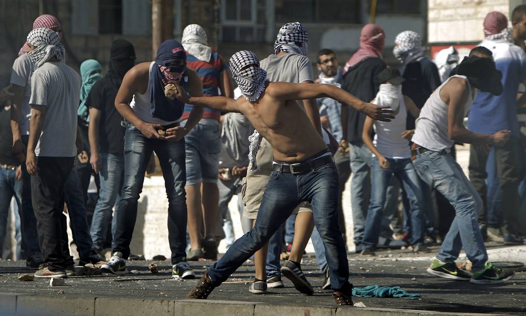 
Manifestantes palestinos mascarados atiram pedras contra a polícia israelense durante confrontos no bairro Shufat, em Jerusalém Oriental
Foto:
AHMAD GHARABLI
/
AFP
