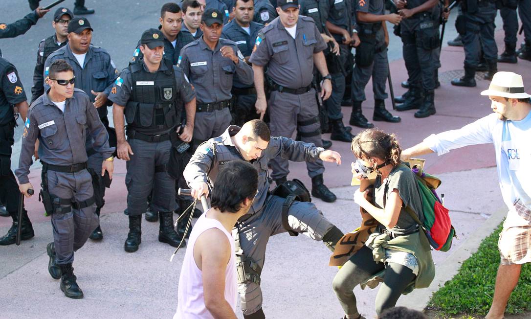Policial chuta manifestante durante protesto na Saens Peña Foto: Marcelo Piu / Agência O Globo