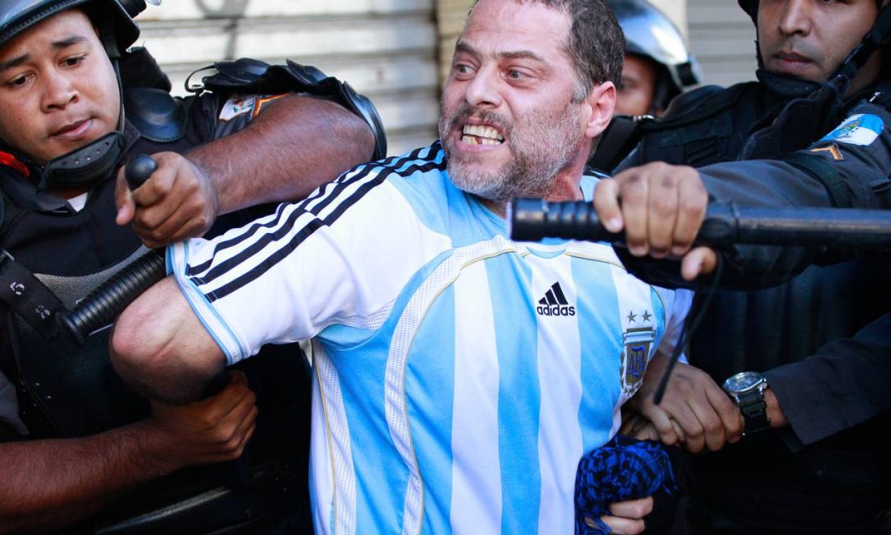 Homem com a camisa da Argentina é imobilizado por policiais em protesto Foto: Marcelo Piu / Agência O Globo