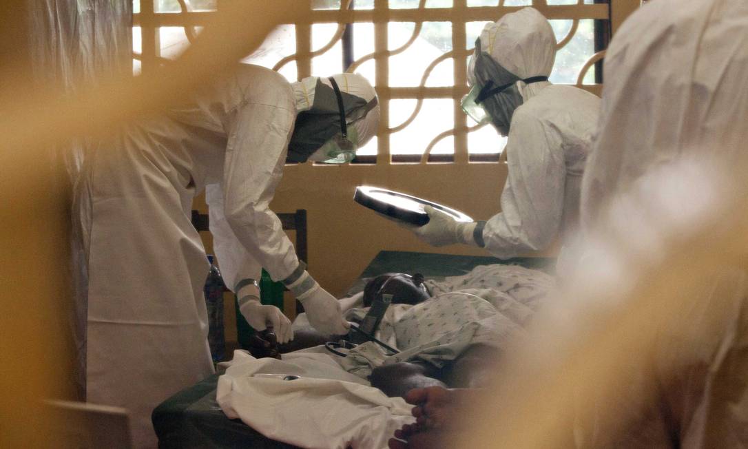 Médicos com equipamentos de proteção cuidam de pacientes de Ebola no centro de gerenciamento de casos em Monrovia, na Libéria Foto: HANDOUT / REUTERS
