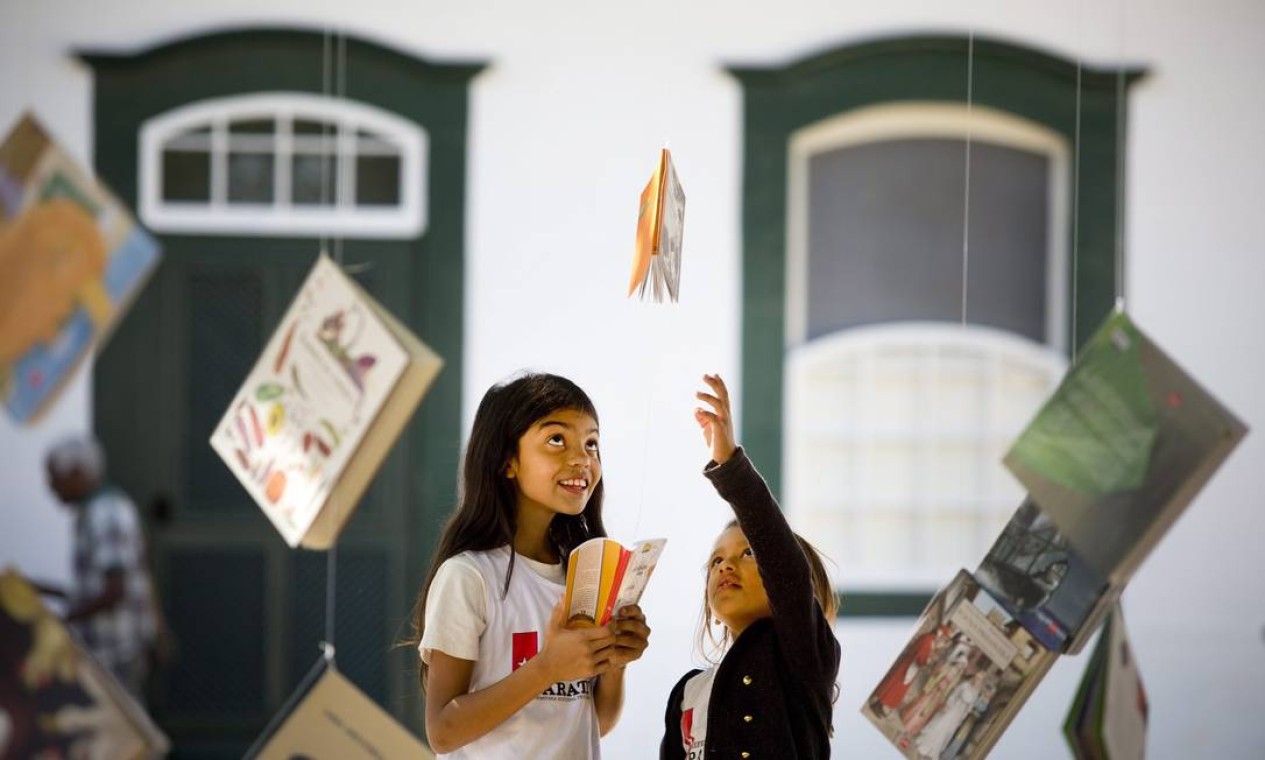 Uma das atrações da festa é a Flipinha, dedicada à criançada. Na foto, duas meninas se encantam com os livros suspensos Foto: Márcia Foletto / Agência O Globo