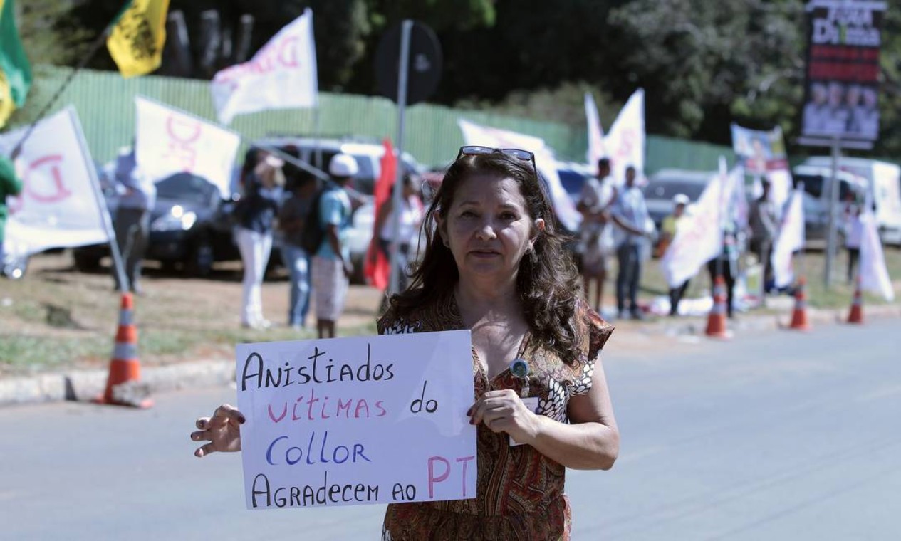 Militante com cartaz do lado de fora da sabatina Foto: Jorge William / O Globo