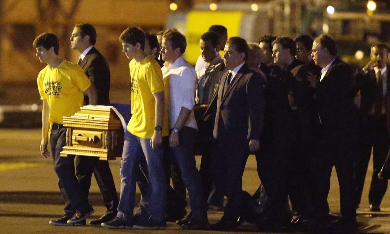João e Pedro, carregam o caixão do pai. Ele e outras três vítimas desembarcaram na base aérea de Recife as 23h05m Foto: PAULO WHITAKER / REUTERS
