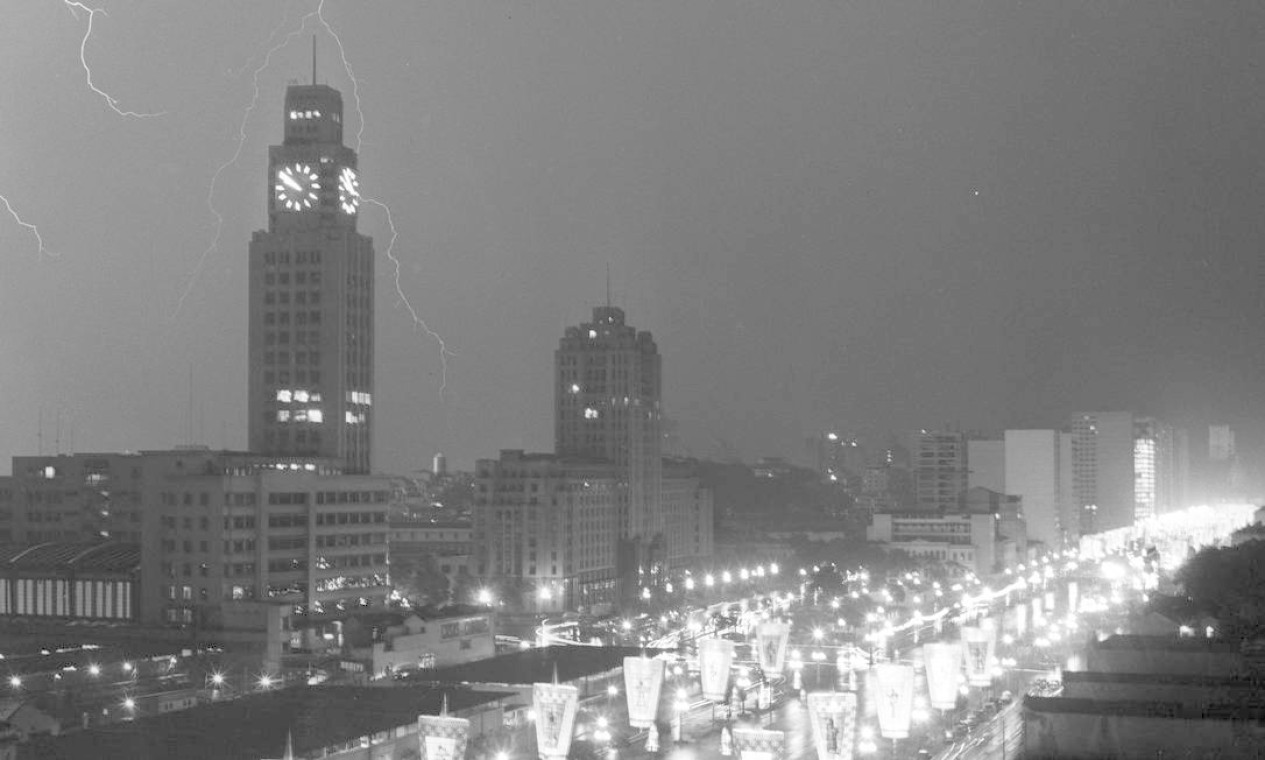 A forte chuva, com raios sobre o prédio da Central do Brasil, em 2 de março de 1965, prejudicou o desfile das grandes sociedades. Na foto, a Avenida Presidente Vargas vazia, porém com ornamentação de carnaval Foto: Agência O Globo