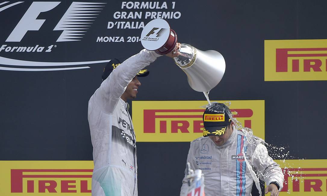 Vencedor do GP da Itália, Lewis Hamilton joga champanhe sobre o brasileiro Felipe Massa, terceiro colocado na prova Foto: OLIVIER MORIN / AFP