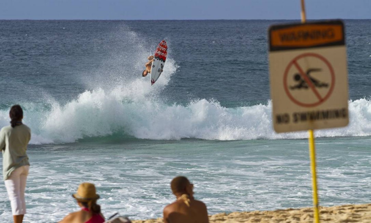 A placa proíbe o nado, mas não há proibição para os voos de Medina no Havaí Foto: Paulo Barcellos / Divulgação