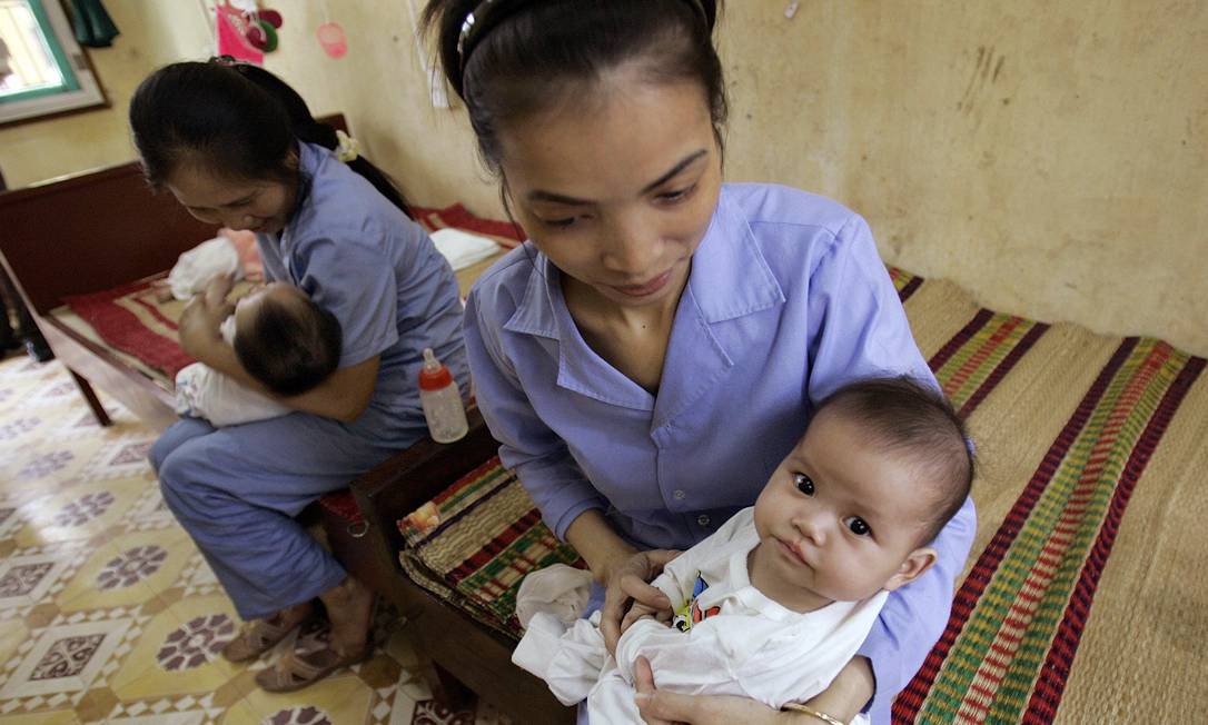 Funcionárias cuidam de bebê em orfanato de Bac Ninh. A foto foi feita em 2008, antes da proibição Foto: Chitose Suzuki / AP
