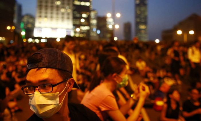 Manifestantes bloqueiam a rua do centro financeiro de Hong Kong e são alvo de spray de pimenta e gás lacrimogênio, lançados pela polícia
Foto: CARLOS BARRIA / REUTERS