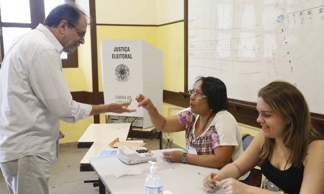 Eleitor diante dos mesários em seção de Niterói Foto: Ana Branco / Agência O Globo