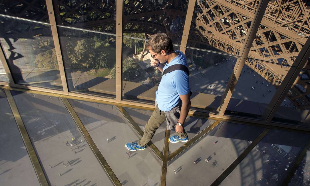 
Visitante caminha sobre o novo piso de vidro do primeiro andar da Torre Eiffel, a 57 metros de altura, em Paris
Foto:
LIONEL BONAVENTURE
/
AFP
