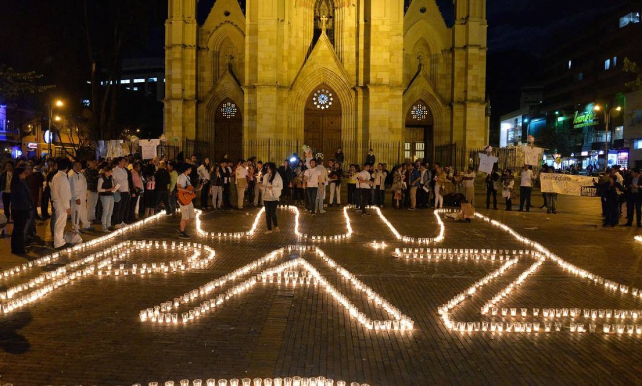 Colombianos escrevem "Paz" usando velas em junho, após anúncio de diálogos entre o governo e o ELN. Grupo agora afirma que manterá diálogos separados das negociações travadas pelas FARC Foto: DIANA SANCHEZ / AFP