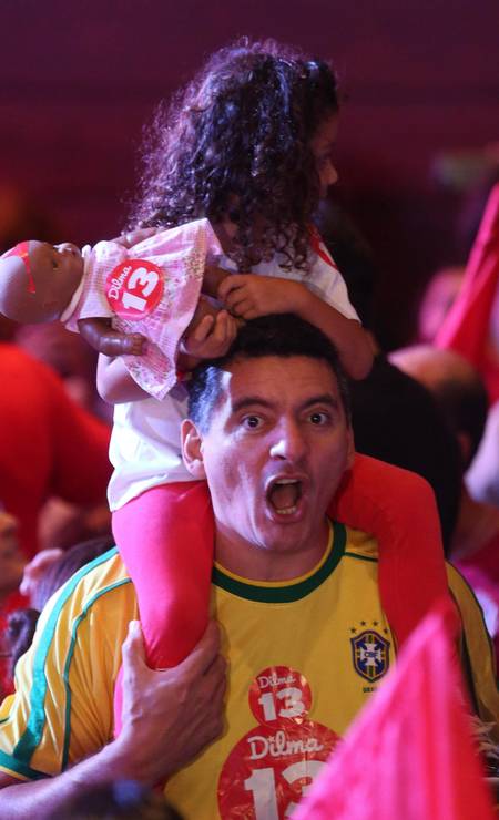 Com um uniforme da seleção brasileira, homem comemora junto com criança Foto: ANDRE COELHO / Agência O Globo
