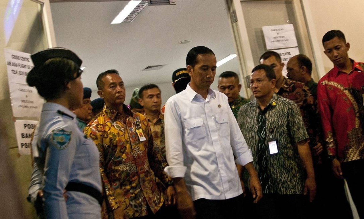 No aeroporto, o presidente indonésio, Joko Widodo (centro), se reúne com familiares das vítimas Foto: JUNI KRISWANTO / AFP