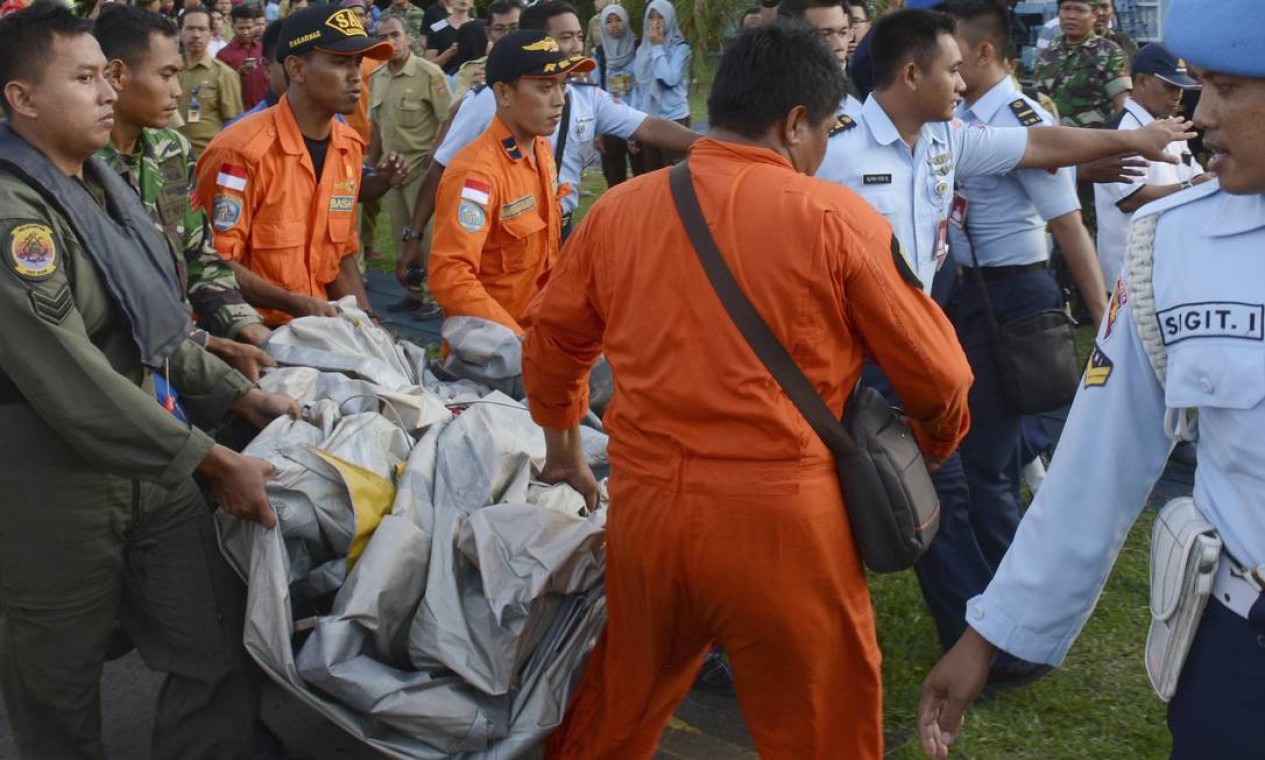 Equipe da Força Aérea da Indonésia transporta peças do avião retiradas do mar Foto: Dewi Nurcahyani / AP