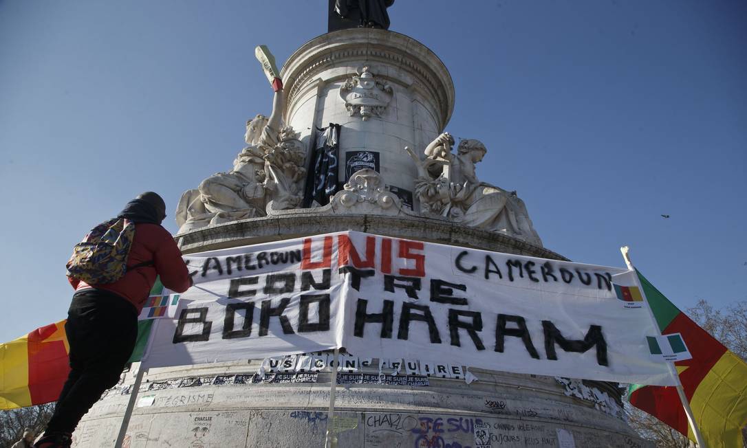 
Camaronesa exilada em Paris ajusta um cartaz com a mensagem “Camarões unidos contra Boko Haram” na Praça da República
Foto:
Michel Euler/AP
/
