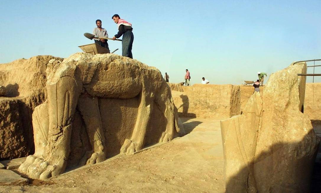 Trabalhadores iraquianos limpam estátua assíria de leão alado em Nimrod em julho de 2001. Ministério iraquiano informou nesta sexta-feira que Estado Islâmico iniciou destruição do sítio arqueológico no Iraque Foto: Karim Sahib 