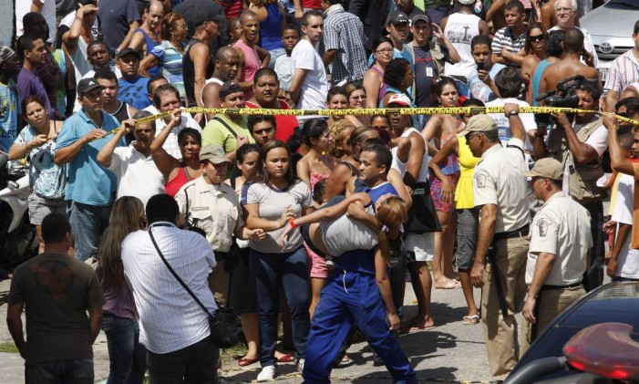 Massacre. Uma aluna da Escola Municipal Tasso da Silveira é carregada após a morte de 12 jovens Foto: Wania Corredo 07/04/2011 / Agência O Globo