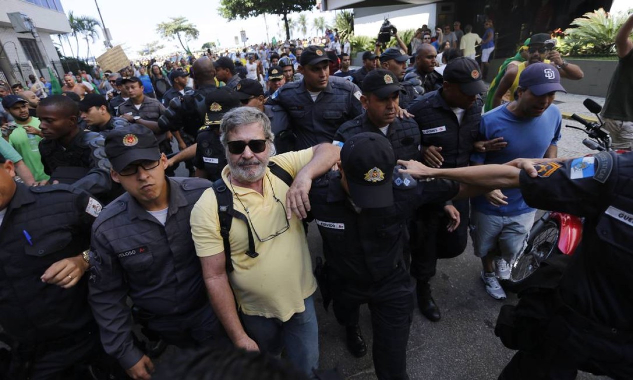 Homem contrário à manifestação teve de ser retirado pelas forças policias início de tumulto, no Rio Foto: Domingos Peixoto / Agência O Globo